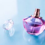 Pink perfume bottle on glossy background, sweet floral scent, gl
