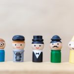 Wooden doll with  happy face on wooden background
